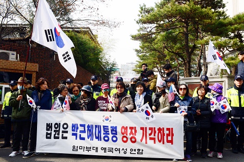 ▲ 박근혜 전 대통령 영장실질심사를 하루 앞둔 지난 3월 29일 오후 서울 강남구 삼성동 박 전 대통령 자택 앞에서 엄마부대 애국여성연합 회원들이 '구속영장 기각' 구호를 외치고 있는 모습. <사진제공=뉴시스>