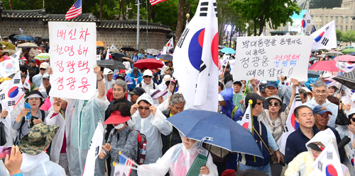 ▲ 13일 오후 서울 중구 덕수궁 대한문 앞에서 열린 '제7차 탄핵무효 국민저항 총궐기 국민대회'에 참석한 국민저항본부 및 보수단체 회원들이 정광용 박사모 회장을 규탄하는 피켓을 들고 있다. <사진제공=뉴시스>