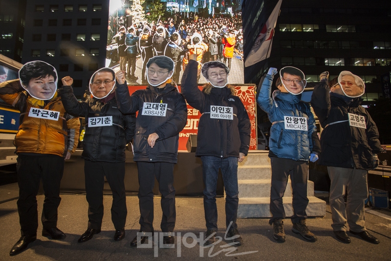 ▲ 2016년 12월 8일, 여의도 새누리당사 앞에서 언론노조 KBS본부를 비롯한 언론노조 조합원 천여명이 '언론부역자 청산, 언론장악 방지법 즉각 제정' 총력투쟁결의대회를 열었다. 참가자들은 박근혜 대통령, 김기춘 전 대통령비서실장, 고대영 KBS사장, 이인호 KBS이사, 고영주 방문진 이사장, 안광한 MBC 사장 탈을 쓴 사람들을 포승줄로 묶어 끌고 가는 퍼포먼스를 펼쳤다. (사진 : 미디어오늘)