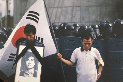 ▲ ‘MBC 6.10항쟁 다큐’의 주인공인 킴 뉴튼 교수가 1987년 7월8일 이한열 열사 장례식에서 찍은 사진. 더불어민주당 우상호 의원(좌)과 배우 우현씨(우). <사진출처=문재인 대통령 페이스북>