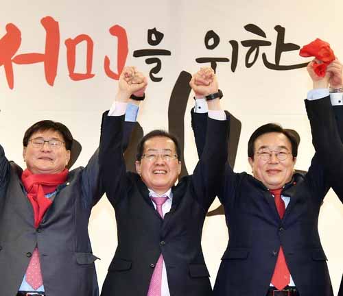 ▲ 홍준표 자유한국당 대표가 15일 부산 벡스코 컨벤션홀에서 열린 부산시당 신년인사회에 참석, 부산지역 국회의원들과 무대에 올라 당원들에게 손을 들어 인사하고 있다.<사진제공=뉴시스>