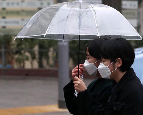 ▲ 미세먼지속 겨울비가 내린 16일 오후 서울 종로구 도심에서 마스크와 우산을 쓴 시민이 발걸음을 재촉하고 있다. <사진제공=뉴시스>