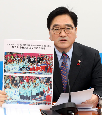 ▲ 우원식 더불어민주당 원내대표가 23일 오전 서울 영등포구 여의도 국회에서 진행된 원내대책회의에서 자유한국당의 전신인 새누리당 의원들이 2014인천아시안게임 여자축구 결승전 북한과 일본 경기에서 북한을 응원하는 사진을 들어보이며 자유한국당은 평창올림픽의 남북단일팀에 대해서 딴지를 걸지 말라며 모두발언을 하고 있다. <사진제공=뉴시스>