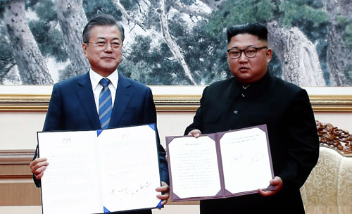 ▲ 19일 서울 동대문디자인플라자(DDP)에 차려진 남북정상회담 서울 프레스센터 대형 화면에 문재인 대통령과 김정은 위원장의 합의문 서명 뒤 기념촬영 하는 장면이 중계되고 있다. <사진제공=뉴시스>