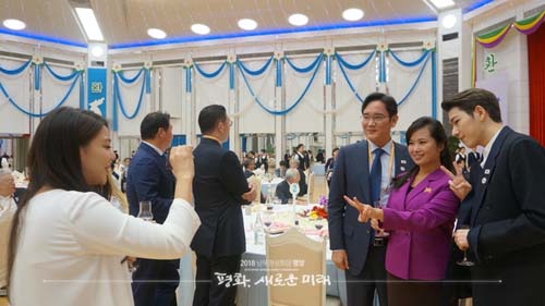 ▲ 지난 달 18일 평양 남북정상회담 첫 공식 만찬장에서 가수 에일리가 이재용 삼성전자 부회장과 현송월 삼지연 관현악단장, 가수 지코의 기념 사진을 찍어주고 있다.<사진=청와대>