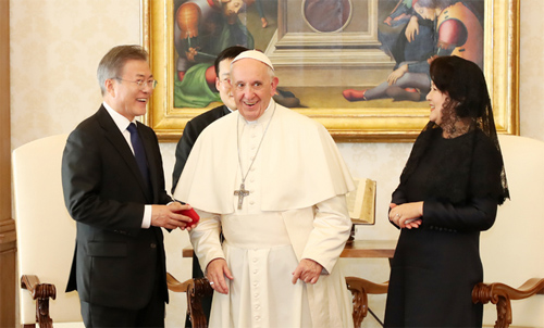 ▲ 문재인 대통령이 18일 로마 바티칸 교황궁 교황 집무실에서 프란치스코 교황으로부터 묵주를 받고 있다. <사진제공=뉴시스>