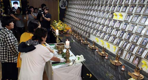 ▲ 지난 9월3일 오후 전남 진도군 임회면 팽목항에 설치됐던 세월호 참사 희생자 분향소가 철거되는 가운데 유가족들이 마지막 헌화를 하고 있는 모습. <사진제공=뉴시스>