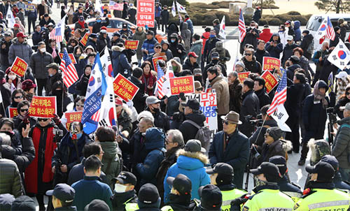 ▲ 5.18 폄훼 망언으로 물의를 빚은 자유한국당 김진태, 김순례, 이종명 의원을 징계하는 여부를 논의하는 당 윤리위원회가 모처에서 비공개로 열린 13일 오후 서울 여의도 국회 본청 앞으로 김진태 의원을 비호하는 '태극기 부대' 회원들이 진입, 불법 집회를 하며 성조기 등을 들고 김 의원 등에 대한 윤리위 제소 철회를 촉구하고 있다. <사진제공=뉴시스>