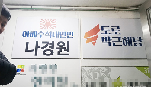 ▲ 6.15공동선언실천 남측위원회 서울본부 회원들이 13일 오전 서울 동작구 자유한국당 나경원 원내대표의 지역구 사무실을 찾아 전날 나 원내대표의 국회 원내교섭단체 국회 연설을 규탄하며 사무실 현판을 바꿔다는 퍼포먼스를 하고 있다. <사진=6.15남측위 서울본부 제공, 뉴시스>