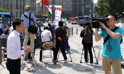 ▲ 6일 오전 서울 광화문 세종대로에 중구청이 제74주년 광복절을 맞아 태극기와 함께 일본제품 불매와 일본여행 거부를 뜻하는 '노 재팬' 배너기를 가로변에 설치, 일본 방송이 배너기를 취재를 하고 있는 모습. <사진제공=뉴시스>