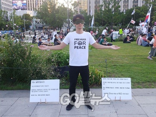 'NO 아베' 6차 촛불집회가 열리고 있는 24일 오후, 한 일본인이 안대를 낀 채 프리허그를 진행하고 있다. ⓒ 신예섭