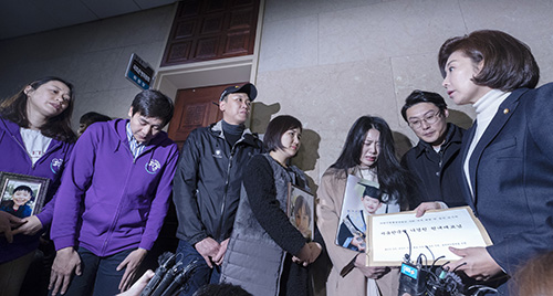 ▲ 교통사고로 아이를 잃은 해인·하준이·태호·민식 가족이 26일 오후 서울 여의도 국회 운영위원장실 앞에서 영정을 들고 나경원 자유한국당 원내대표에게 아이들의 이름을 딴 어린이 생명안전법안 통과를 호소하고 있다. <사진제공=뉴시스>