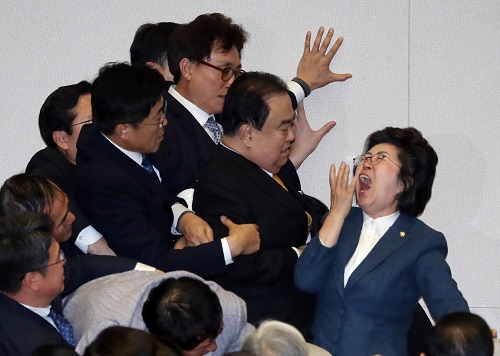 ▲ 문희상 국회의장이 27일 서울 여의도 국회에서 열린 제373회국회(임시회) 제1차 본회의에서 의장석으로 향하고 있다. 이은재 의원을 비롯한 자한당 의원들이 그를 필사적으로 막고 있는 모습. <사진제공=뉴시스>