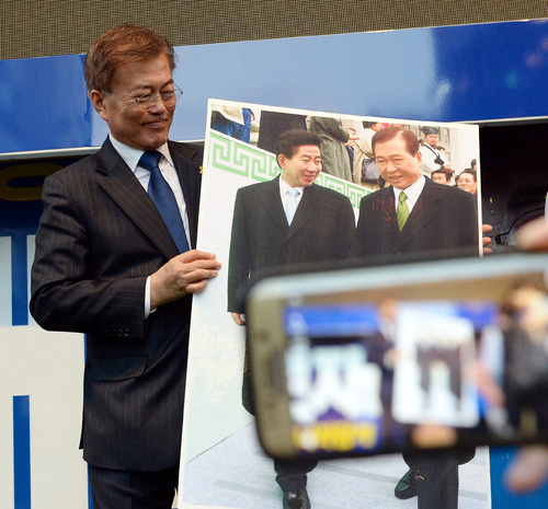 ▲ 2017년 4월18일 당시 문재인 더불어민주당 대선후보가 광주광역시 동구 충장로 입구에서 진행된 집중유세에서 시민이 건내준 김대중 노무현 전 대통령의 사진을 들어보이고 있는 모습.<사진제공=뉴시스>