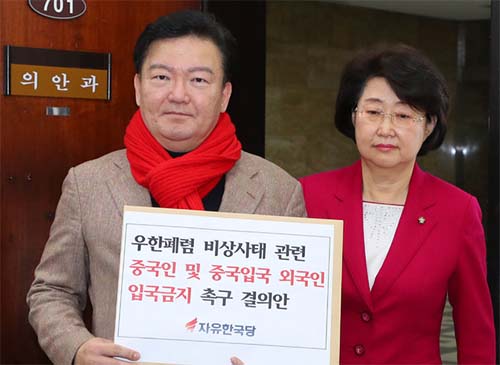 ▲ 자유한국당 민경욱 의원과 김승희 의원이 12일 서울 여의도 국회에서 우한폐렴 비상사태 종료 시까지 중국인 및 중국 입국 외국인의 입국금지 촉구 결의안을 들고 의안과에 입장하고 있다.<사진제공=뉴시스>