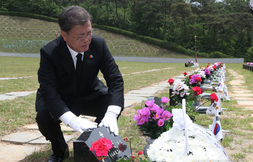 ▲ 문재인 대통령이 제40주년 5·18 민주화운동 기념일인 18일 광주 북구 5·18 민주묘지 제2묘역에서 고(故) 이연 씨 묘를 참배하고 있다. 고인은 전남대 1학년에 재학 중이던 1980년 5월 27일 YMCA 회관에서 계엄군과 총격전 중 체포되어 전신 구타를 당했다.<사진제공=뉴시스>