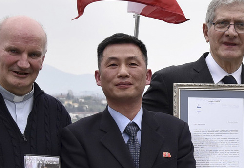 ▲ 2018년 3월20일 조성길(가운데) 이탈리아주재 북한 대사대리가 이탈리아 산피에트로디펠레토에서 열린 문화 행사에서 '로베레토 자유의 종'을 들고 있는 모습.<사진제공=뉴시스>