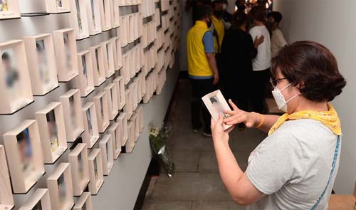 ▲ 지난 7월 27일 오전 서울 광화문 세월호 기억공간에서 한 유가족이 세월호 참사 희생자들의 사진정리하기 전 아들의 사진을 바라보고 있다.유가족은 이날 기억공간 내 물품을 서울시의회에 마련된 임시공간으로 옮겼다. <사진제공=뉴시스>