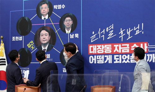 ▲ 송영길 더불어민주당 대표와 최고위원들이 18일 서울 여의도 국회에서 열린 최고위원회의에 앞서 대장동 의혹과 관련해 부산저축은행 부실 수사를 지적하는 내용이 담긴 배경판을 바라보며 대화하고 있다. <사진제공=뉴시스>