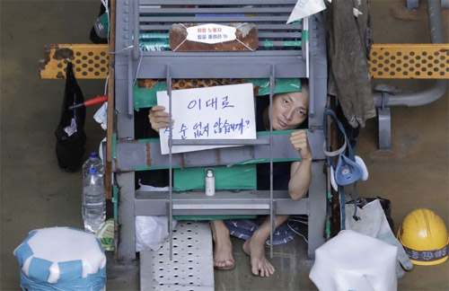 ▲ 민주노총 금속노조 거제통영고성 조선하청지회 유최안 부지회장이 처우개선을 요구하며 가로 세로 높이 1m(1㎥) 쇠창살에 스스로 몸을 가두고 농성을 벌이고 있는 모습.<사진 출처=전국금속노동조합 페이스북>