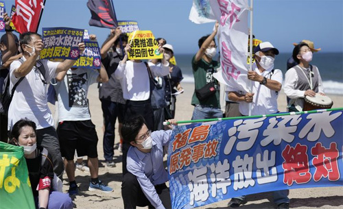 ▲ 24일 일본 후쿠시마현 나미에 해변에서 시위대가 후쿠시마 다이이치 원자력발전소를 향해 오염수 방류 반대 시위를 하고 있다. 이들이 들고 있는 현수막 등에는 '오염수 해양 방류 반대'라고 쓰여 있다. <사진제공=뉴시스>