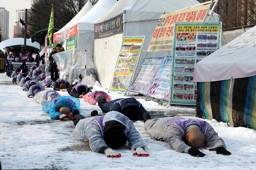 ▲ 눈이 내린 20일 오전 서울 여의도 국회 앞에서 이태원참사 유가족들과 종교인들이 이태원참사 특별법 국회 본회의 통과를 촉구하며 오체투지를 하고 있는 모습. <사진제공=뉴시스>